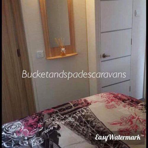 a bedroom with a bed with a mirror and a dresser at Blackpool caravans Marton mere in Blackpool