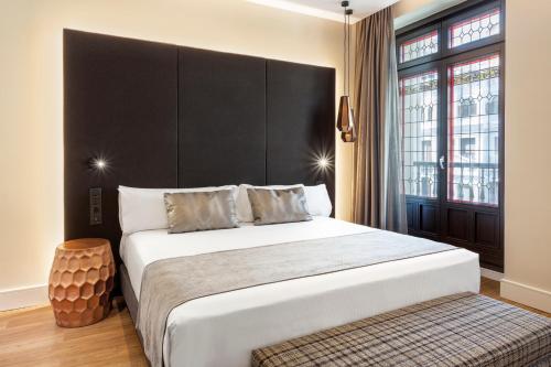 a bedroom with a large bed with a black headboard at Catalonia Gran Vía Madrid in Madrid