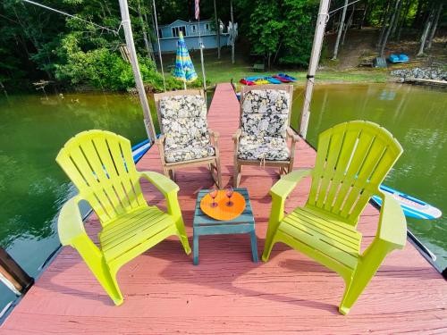 four chairs and a pumpkin on a dock on the water at Paradise View Getaway-Dacha in Hartwell