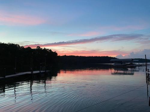 a view of a lake at sunset with a dock at Paradise View Getaway-Dacha in Hartwell