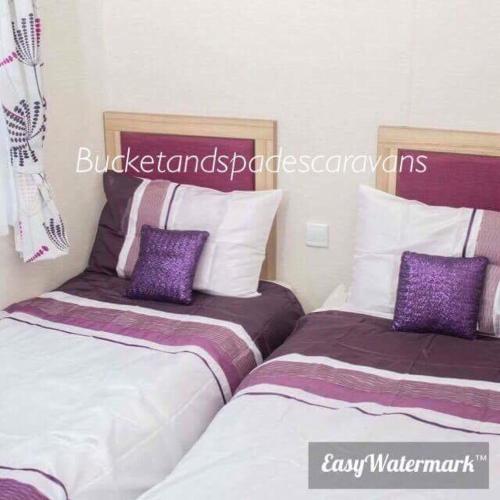 two beds sitting next to each other in a room at Blackpool caravans Marton mere in Blackpool