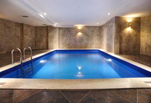 uma piscina num quarto com uma grande piscina azul em Concept Nisantasi Hotels & Spa em Istambul