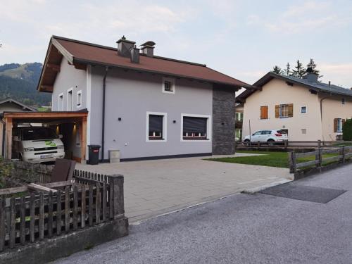 Biały dom z podjazdem i ogrodzeniem w obiekcie Ferienhaus Esila w mieście Fieberbrunn