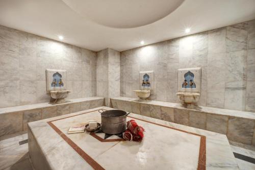 a bathroom with three sinks and a pot on a table at Concept Nisantasi Hotels & Spa in Istanbul