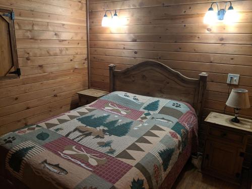 a bedroom with a bed with a quilt on it at Stateline Cabin in Hobbs