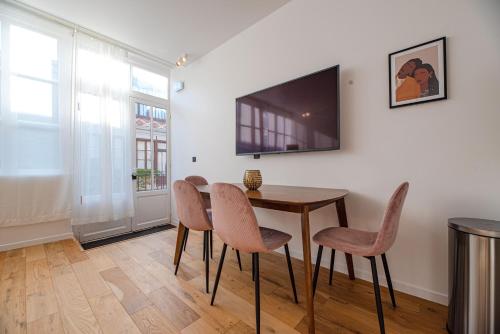 une salle à manger avec une table et des chaises et une télévision dans l'établissement MBM - LOFT MARAIS, à Paris