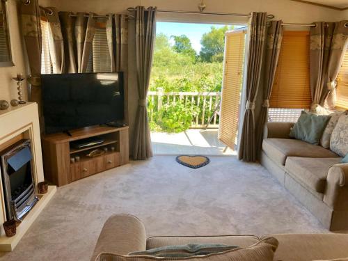 a living room with a couch and a television at Blackpool caravans Marton mere in Blackpool