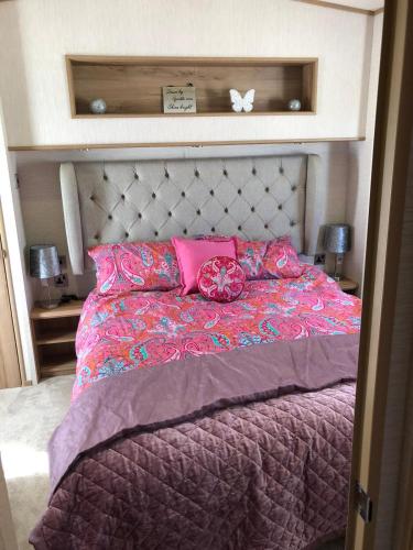a bedroom with a bed with pink sheets and pink pillows at Blackpool caravans Marton mere in Blackpool
