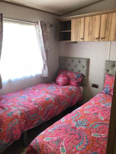 a bedroom with two beds and a window at Blackpool caravans Marton mere in Blackpool
