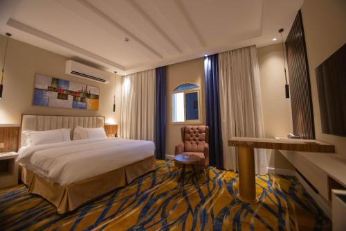 Habitación de hotel con cama y silla en فندق قوبا السويس, en Jazan