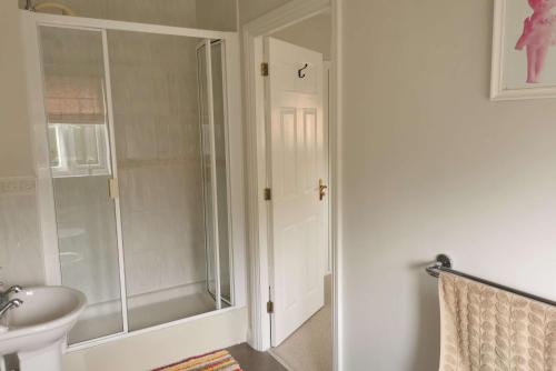 a bathroom with a shower and a sink at Walton Crescent in Winford