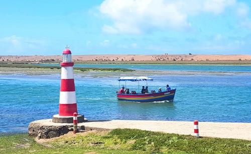 a boat in the water next to a lighthouse at Maison de la Lagune in Oualidia