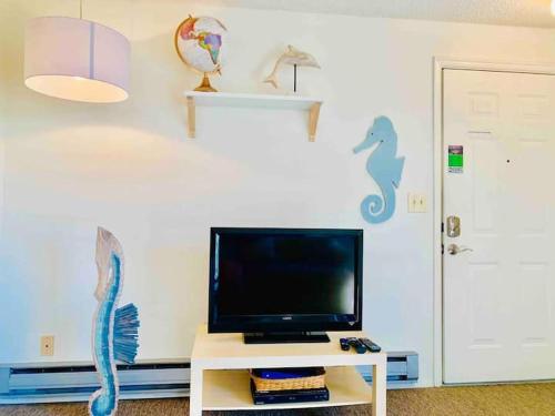 a living room with a tv on a white wall at Unique, Convenient, Centrally located apartment in Kent