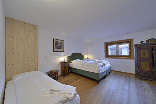 サンモリッツにあるChesa Ilaria - St. Moritzのベッドルーム1室(ベッド2台、窓付)