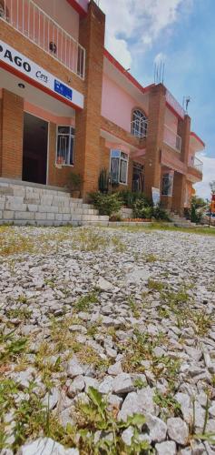 a large building with a stone ground in front of it at Hotel El Rancherito in San Cristóbal