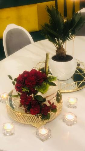 a table with a plate with red flowers and candles at Domek w Pieninach Apartament Pałacowy Liliana in Krościenko