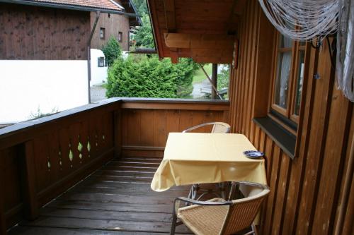 a table and two chairs on a wooden balcony at Haus Schwarz in Staudach-Egerndach