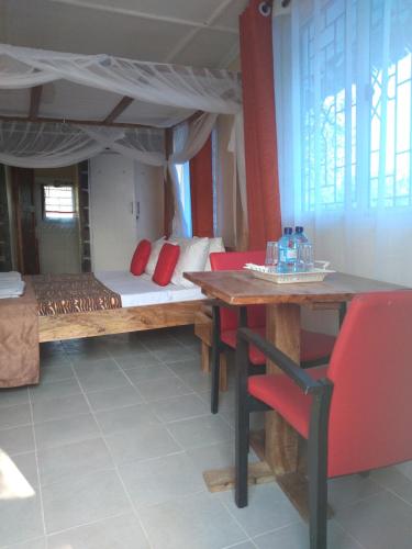 a room with a bed and a table and chairs at Ocean View Nyali Boutique Hotel in Nyali