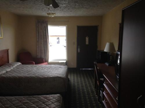 a hotel room with a bed and a window at Regal Inn Guntersville in Guntersville