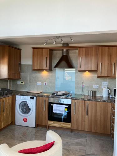 a kitchen with a washing machine and a washer at SWANSEA MARINA VIEW mins to beach, Marina, Swansea Arena, City free parking in Swansea