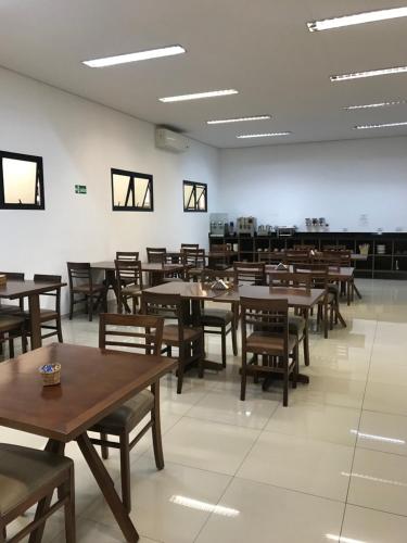a dining room with wooden tables and chairs at Hotel Estrela da Agua Fria in Sao Paulo