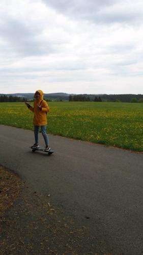 a young child riding a skateboard down a road at Gasthaus Piesau - Thüringer Wald - Rennsteig in Piesau