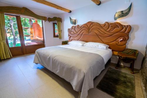
a bedroom with a large bed and a large window at Casa Primal in San José de Maipo
