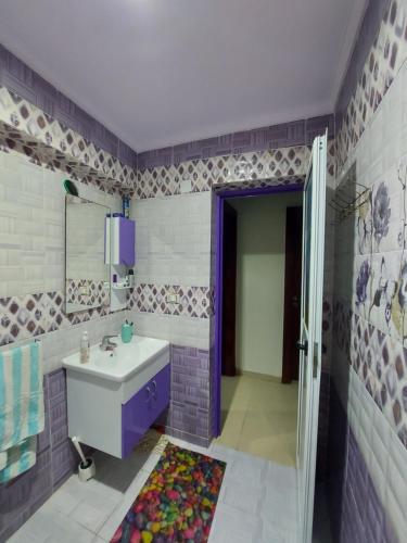 a purple bathroom with a sink and a shower at شقه سوبر لوكس دور ارضى بجنينه بالمعموره الشاطى lovely appartment at mamora beach مع كارنيهات شاطى in Alexandria