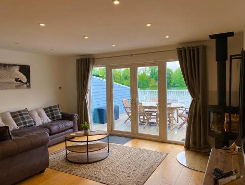 a living room with a couch and a table at Cotswolds Lakeside Lodge - Nesbitt's Nest in South Cerney