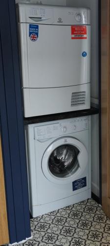 a washer and dryer sitting on top of a washing machine at Drumdelgie Cottages in Huntly