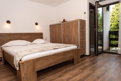 una camera da letto con un letto grande con testiera in legno di K'RAMAN a Râmnicu Vâlcea