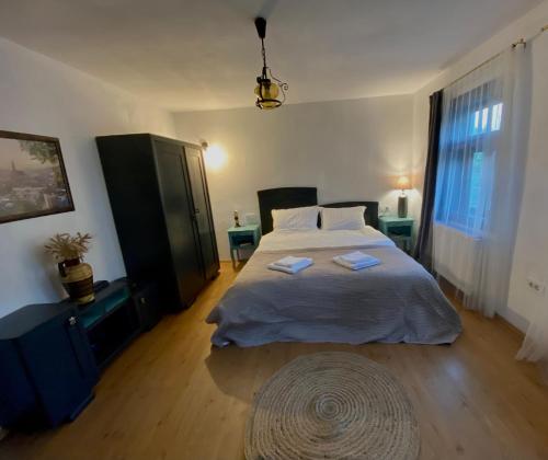 ein Schlafzimmer mit einem Bett mit zwei Handtüchern darauf in der Unterkunft Dock Cottage House in Bădeni