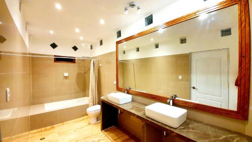 a bathroom with two sinks and a large mirror at Edelmon't Beach in Los Órganos