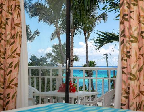 a table on a balcony with a view of the ocean at Orange Hill Beach Inn in Nassau