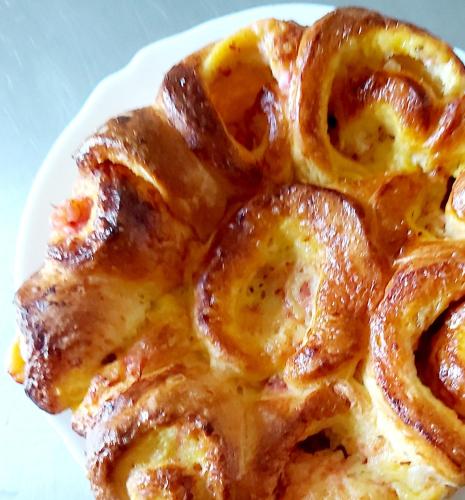 ein weißer Teller mit einem Stück Essen mit Zwiebelringen in der Unterkunft Au pays d'Angeline in La Pacaudière