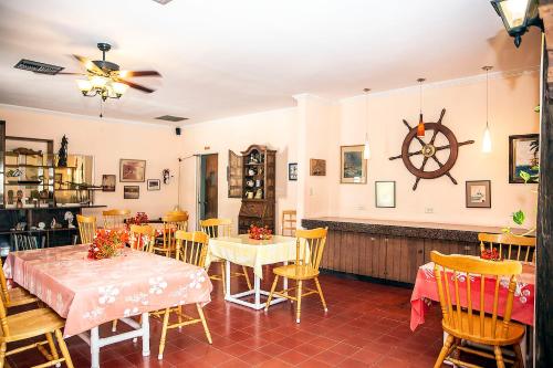 a dining room with tables and chairs and a clock on the wall at Orange Hill Beach Inn in Nassau