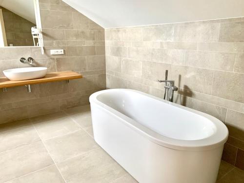 a bathroom with a white bath tub and a sink at Residence Dlouha - Old Town in Prague