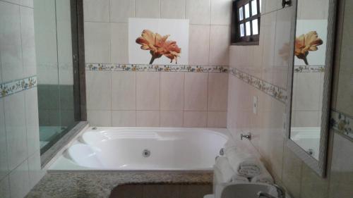 a white bath tub in a bathroom with a sink at Pousada Costa Coral in Tamandaré