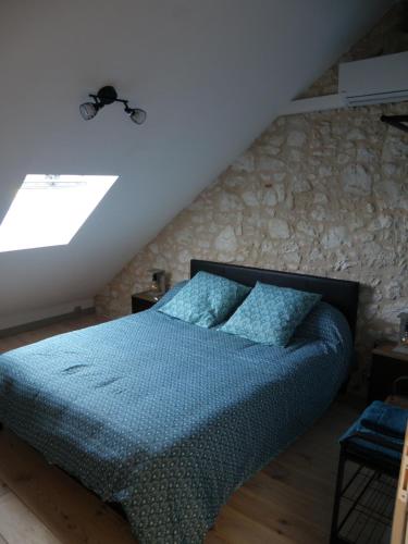 um quarto com uma cama com uma parede de pedra em Ancienne école de Colombier em Colombier