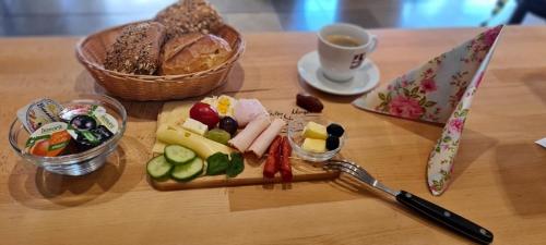 a table with a plate of food and a cup of coffee at Hotel Zur Aue in Wesel