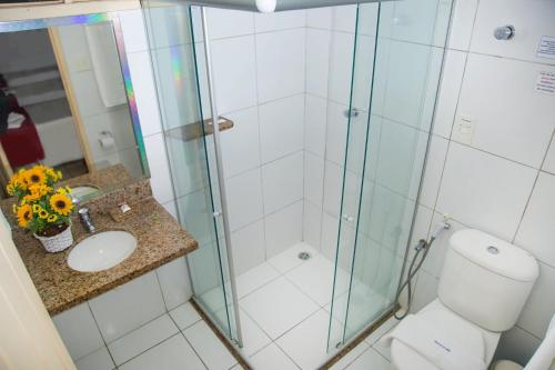 uma casa de banho com um chuveiro, um WC e um lavatório. em Pousada Perola Dourada Maceió em Maceió