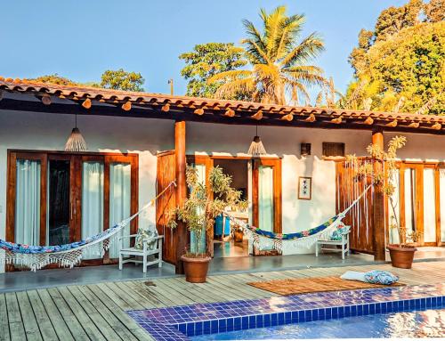 a house with a hammock on a deck with a pool at VILA TRANCOSEAR in Trancoso