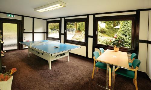 a room with a ping pong table and chairs at Landhotel Goldener Acker in Morsbach