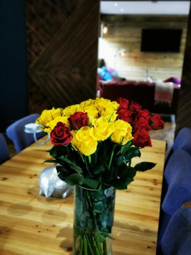 a vase filled with yellow and red flowers on a table at Drumdelgie Cottages in Huntly