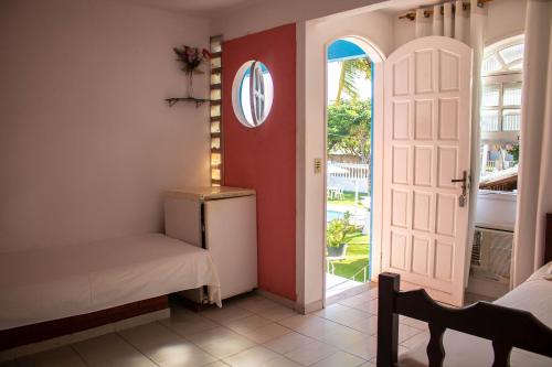 a bedroom with a bed and an open door at Pousada da Bia in Rio das Ostras