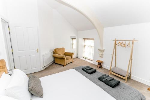 諾里奇的住宿－Stunning Wensum Apartment, Amazing Location，卧室配有一张白色大床和一把椅子