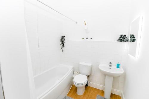 a white bathroom with a toilet and a sink at Stunning Wensum Apartment, Amazing Location in Norwich