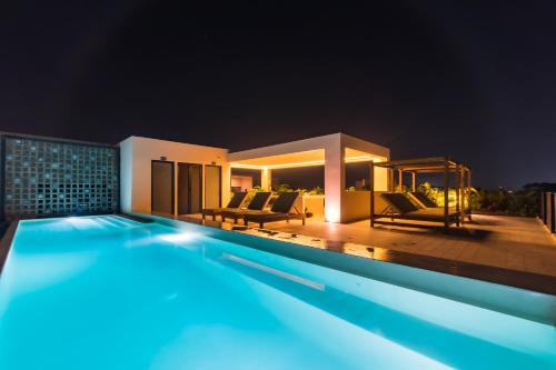 a villa with a swimming pool at night at Kaab At The Park by The Spot Rentals in Playa del Carmen