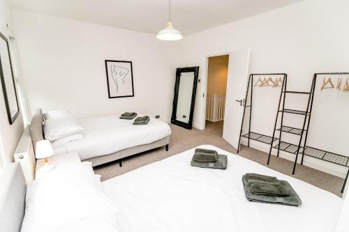 Un dormitorio con dos camas y dos espejos. en New city house, great location - with parking, en Norwich