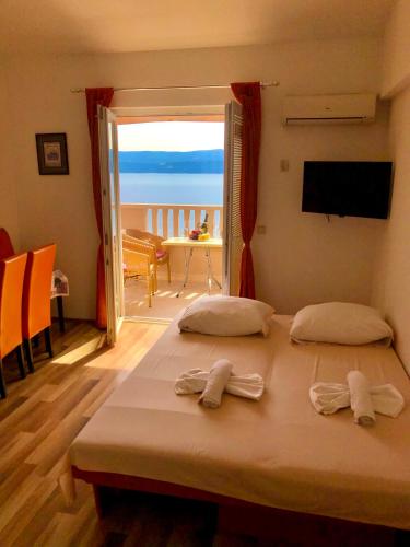 a bedroom with a bed with a view of the ocean at Apartments Anita and Zoran in Stanići